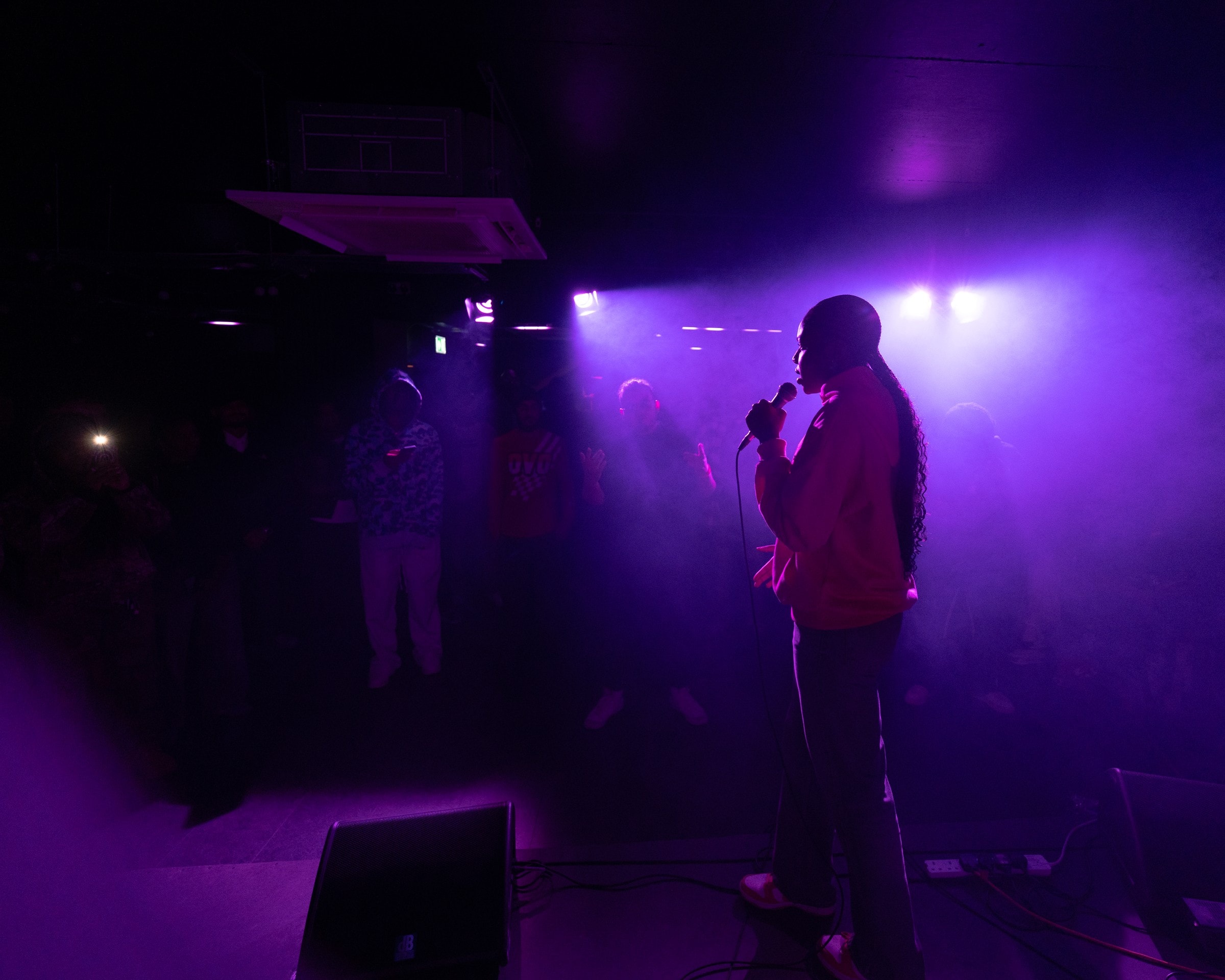 An artist performing under purple light