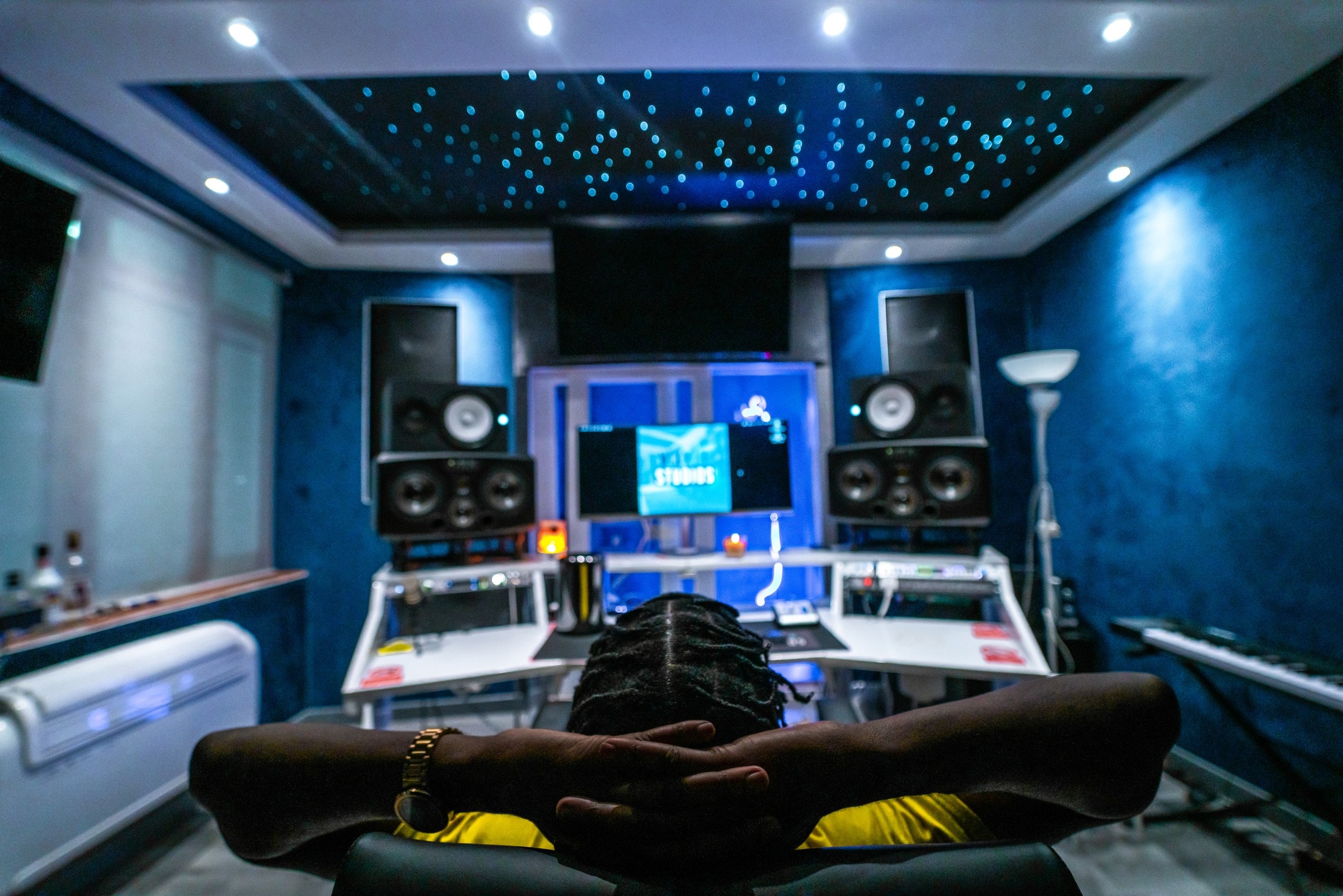 A producer in a control room under a starlit ceiling