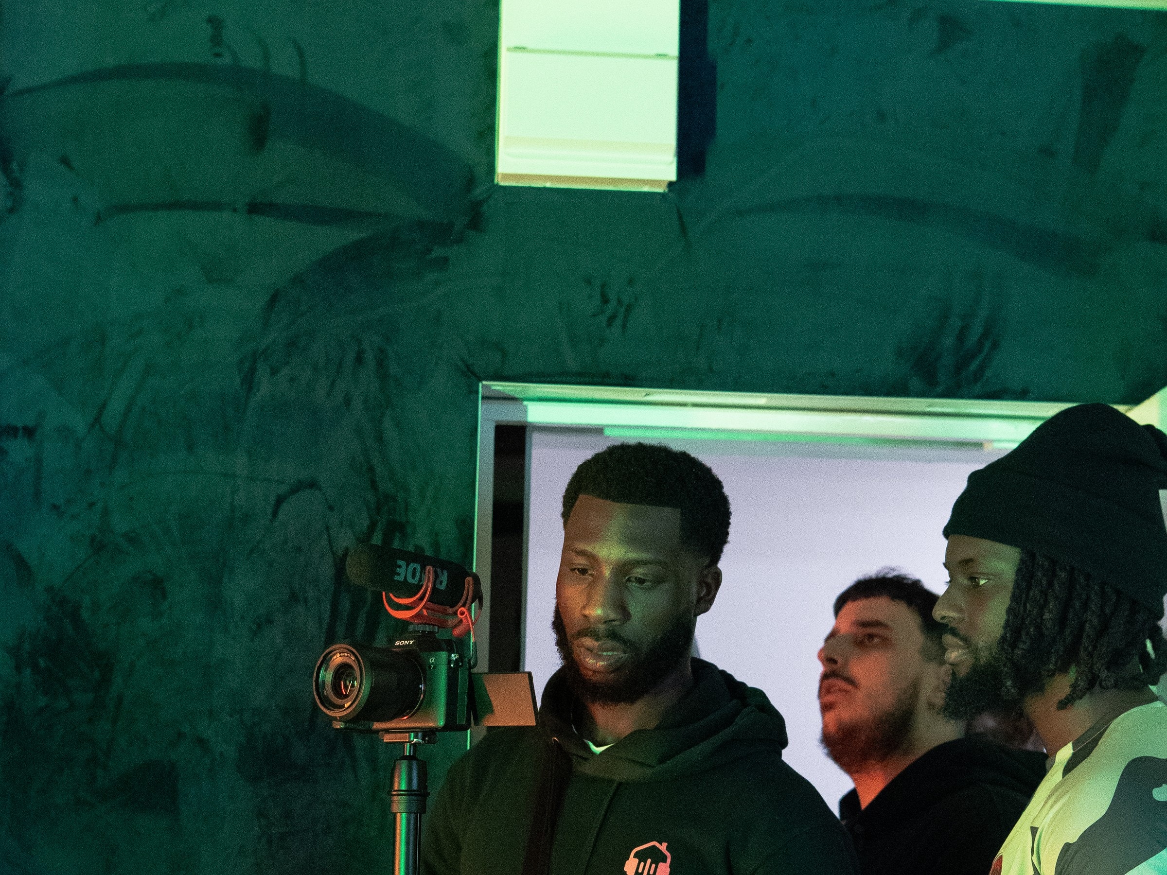 A crew framing a shot in a green-lit studio