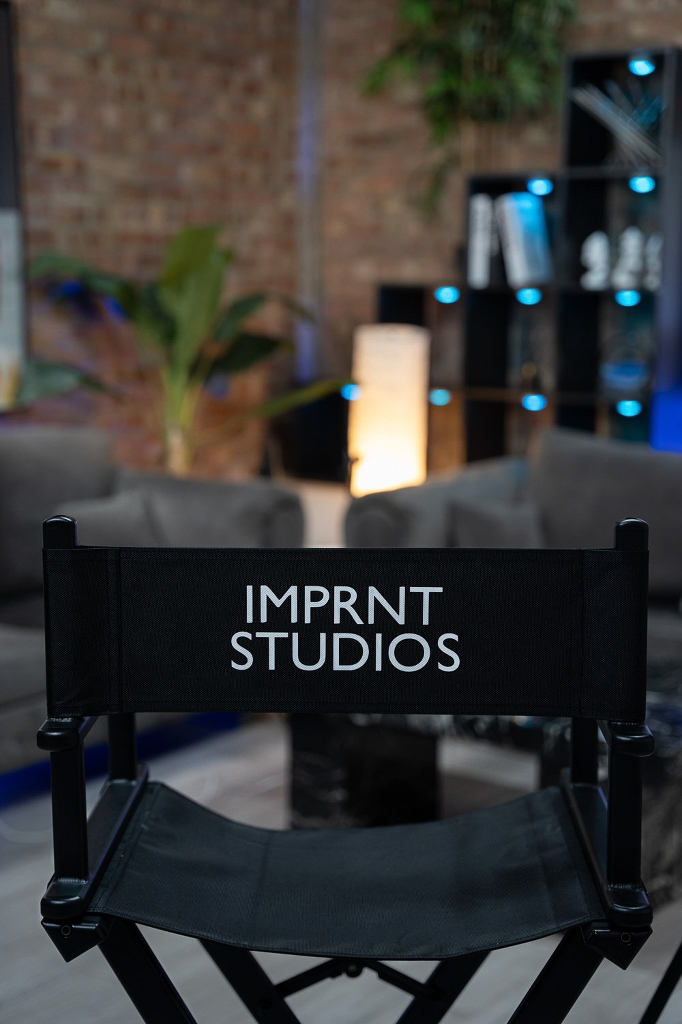 A podcast lounge with blue sofas and mics on stands